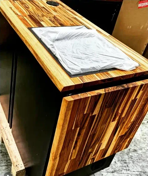 The Banger out of its crate, packed down: a flat teak top with the sink covered and a teak wing folded down against the side.